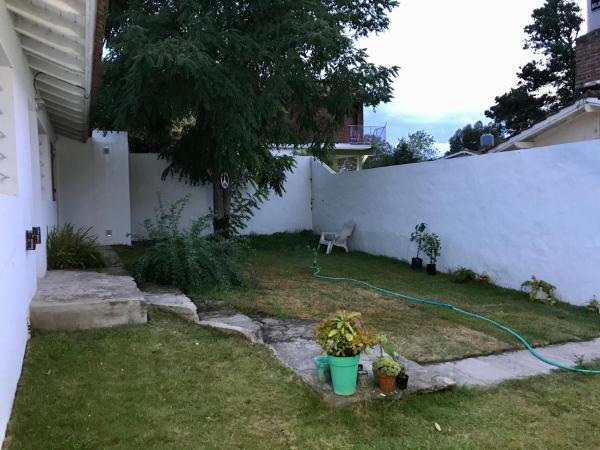 un patio con una valla blanca y una manga verde en el Departamento Jardín - 1 en Villa Gesell