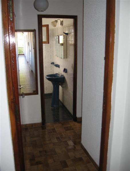 pasillo con baño con aseo y espejo en DLorena en Villa Gesell