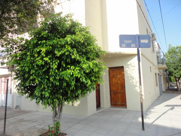 un árbol frente a un edificio con un letrero en la calle en El Buen Descanso en Gualeguaychú