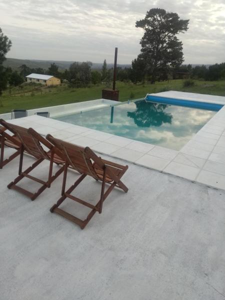 un par de sillas sentadas junto a una piscina en Portalmorada, en Villa Yacanto