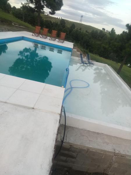 una piscina con sillas al lado en Portalmorada, en Villa Yacanto