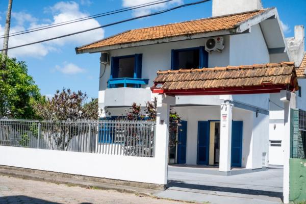 a white house with a red roof at Casa AZUL - A 70 Metros da Areia da Praia dos Ingleses - 6 Pessoas in Florianópolis