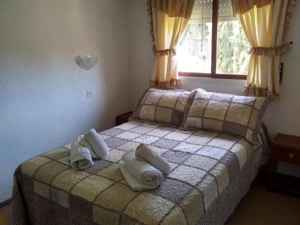 un dormitorio con dos toallas en cama con ventana en el Hotel La Terraza de Villa Gesell