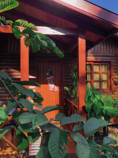 una pequeña casa con columnas naranjas y plantas verdes en Terra Lodge en Puerto Iguazú