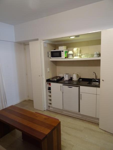 una pequeña cocina con mesa y microondas en Arenales Apartamento en Buenos Aires