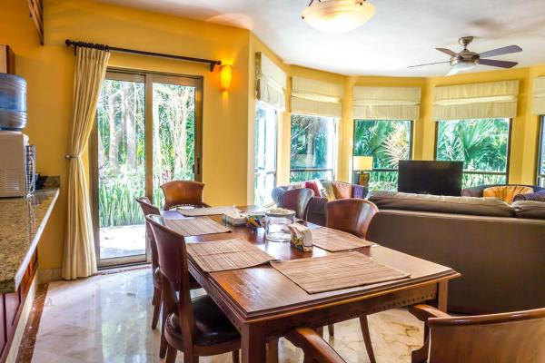 comedor con mesa y sofá en Paseo del Sol Coral A 105 condo, en Playa del Carmen