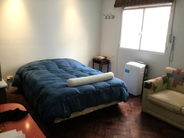 1 dormitorio con 1 cama con manta azul y ventana en Cozy studio in Palermo, Las Cañitas 300MB en Buenos Aires