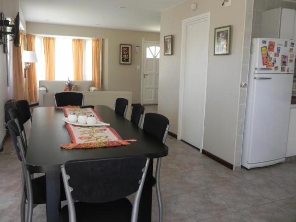 cocina y comedor con mesa negra y sillas en Picun Cuyen en Villa Gesell
