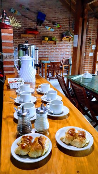 una mesa con platos de bollería y tazas en el Hostal La Gran 7 de Villa Gesell