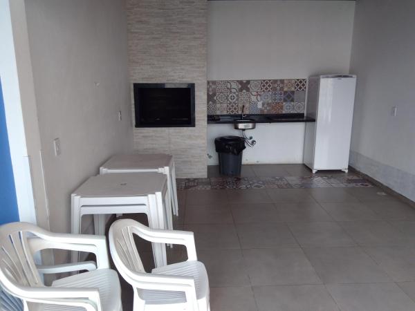 a room with white chairs and a table and a refrigerator at Estrela do Mar in Florianópolis