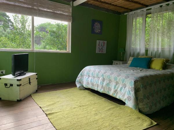 Dormitorio verde con cama y TV en Pensamientos del alma en Balneario Mar Azul