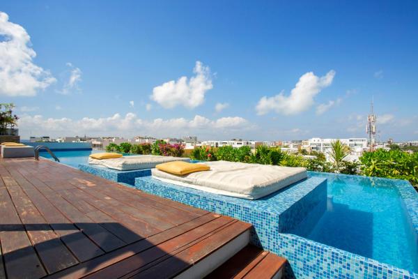 una piscina con cama en la parte superior de un edificio en Lovely One Bedroom With Amazing Terrace View, en Playa del Carmen