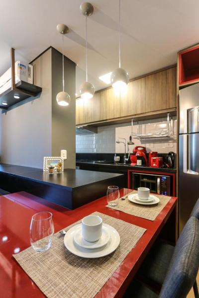 a kitchen with a table with plates and glasses on it at Studio Berlin - Central - 7th012 in Curitiba