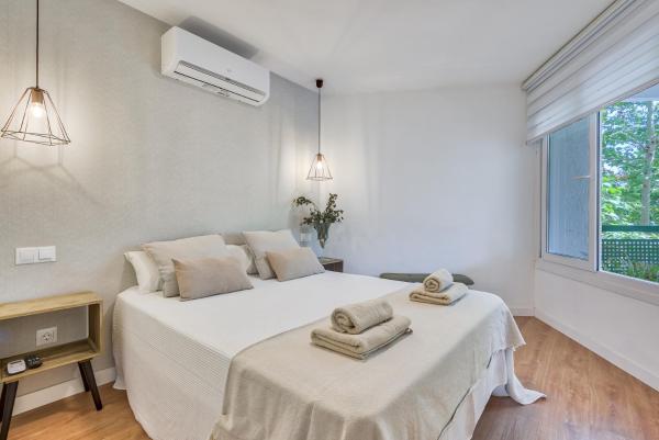 1 dormitorio blanco con 2 camas y ventana a Sur Suites Pauli, en Fuengirola