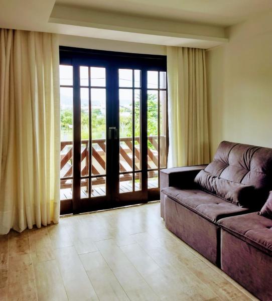 sala de estar con sofá y puerta corredera de cristal en SOBRADO 250 MTS PRAIA MARISCAL Algodoeiro 249-4, en Bombinhas