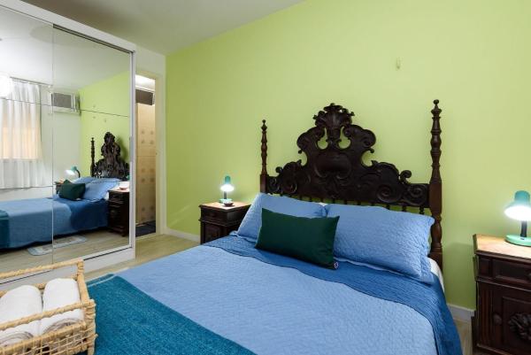 1 dormitorio con cama azul y espejo grande en Omar do Rio, Quadra da Praia de Ipanema com Garagem a 08 minutos do metrô, Smart TV & Internet 240mbps, PM 206, en Río de Janeiro