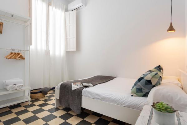 1 dormitorio pequeño con 1 cama y suelo a cuadros en HSH Suites Campana, en Sevilla