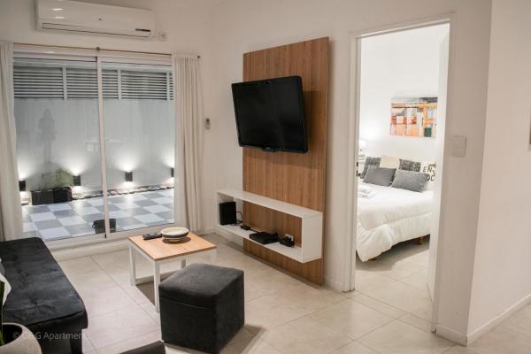 sala de estar con cama y TV en la pared en G&G Apartments - Obelisco Perfect location en Buenos Aires