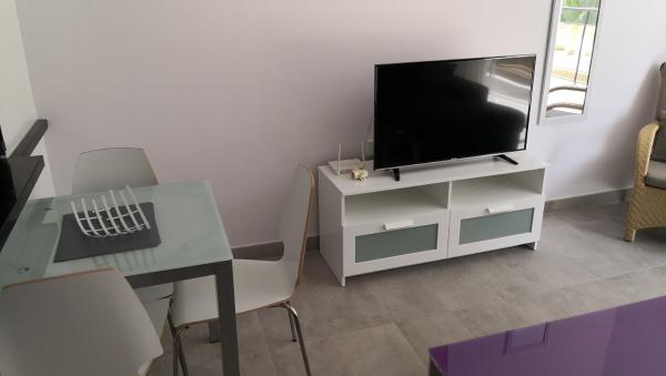sala de estar con TV y escritorio con ordenador en Skol 320C by Completely Marbella, en Marbella