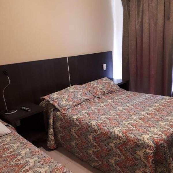 una habitación de hotel con dos camas y una mesa en la avenida 1 de Villa Gesell