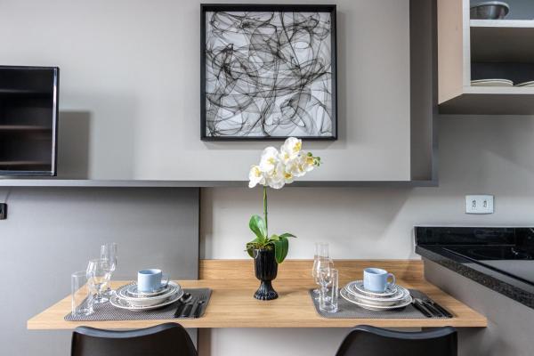 a kitchen with a wooden table with a vase of flowers at Vista Passeio Público - AYN027 in Curitiba