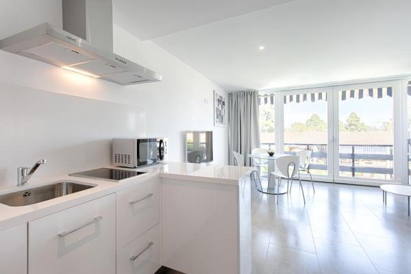 cocina blanca con armarios blancos y comedor en San Pedro Apartment, en Marbella