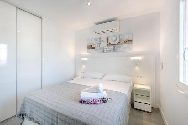 Un dormitorio blanco con una cama blanca con flores. en San Pedro Apartment, en Marbella