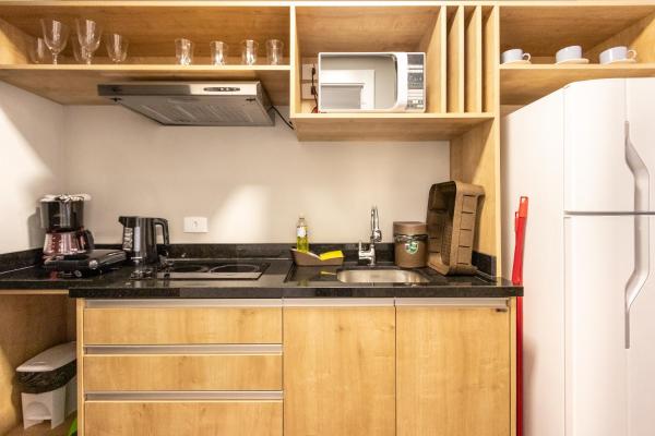 a small kitchen with a sink and a refrigerator at Studio Serra do Mar - Central - AYN029 in Curitiba