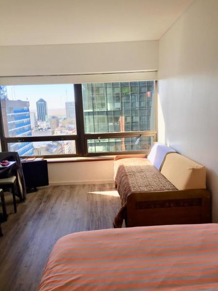 Habitación de hotel con 2 camas y ventana grande. en edificio corrientes818 en Buenos Aires
