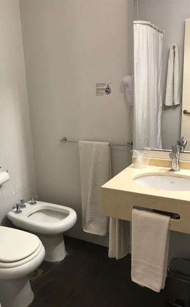 Baño blanco con aseo y lavamanos en Hotel Crillon Mendoza en Mendoza