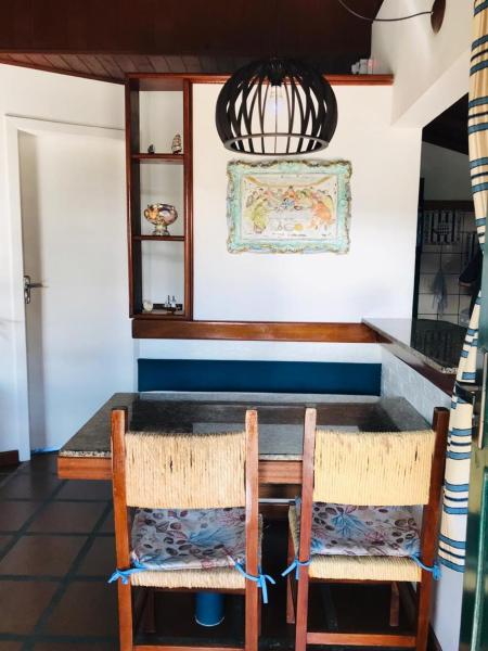 a dining room table with two chairs and a light at Casa Chale 10 Florianópolis in Florianópolis