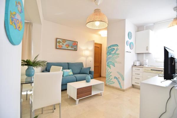 sala de estar con sofá azul y cocina en Coqueto apartamento a 5min.  del centro histórico, en Málaga