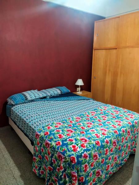 a bedroom with a bed with a floral bedspread at Departamento céntrico en Santa Fe capital in Santa Fe