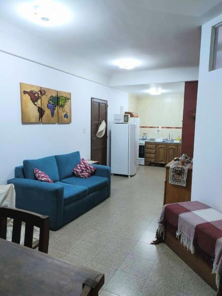 a living room with a blue couch and a kitchen at Departamento céntrico en Santa Fe capital in Santa Fe