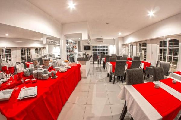 un restaurante con mesas rojas y sillas en una habitación en Hotel Casablanca, en Mina Clavero