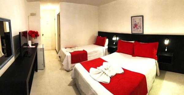 Habitación de hotel con 2 camas con almohadas rojas en Hotel Casablanca, en Mina Clavero
