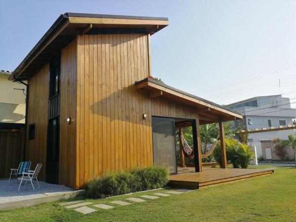a small wooden house with a deck in a yard at Exclusive EcoHouse! Privacy 100 m Praia Campeche in Florianópolis