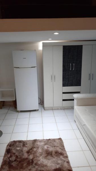 una cocina con armarios blancos y una alfombra en el suelo en Apartamento Loft Urca, en Río de Janeiro