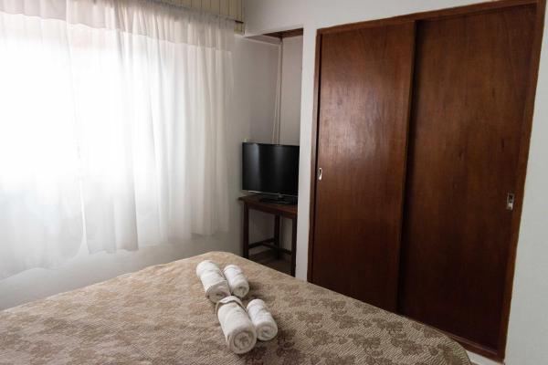 un dormitorio con cama con toallas en el Hotel Nuevo Horizonte de Villa Gesell
