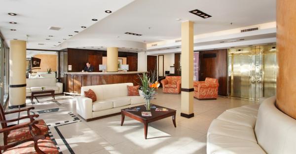 sala de estar con sofá blanco y mesa en Embajador Hotel en Buenos Aires
