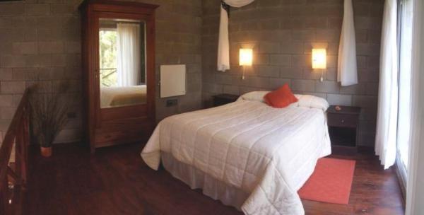 1 dormitorio con cama blanca y espejo en Loft Hadas del Bosque en Mar de las Pampas