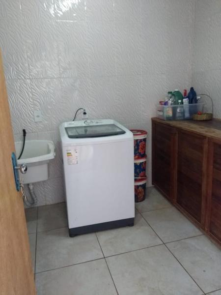 a small refrigerator in a kitchen next to a sink at Casa no Campeche com Piscina in Florianópolis