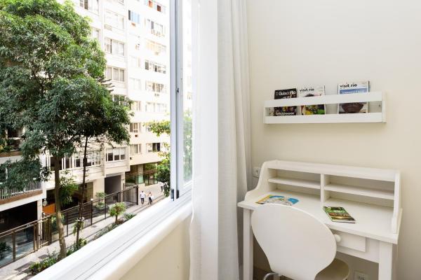 escritorio blanco y silla en una habitación con ventana en Pineapples DF219 - Apartamento a 100m da Praia de Copacabana perfeito para casais, en Río de Janeiro