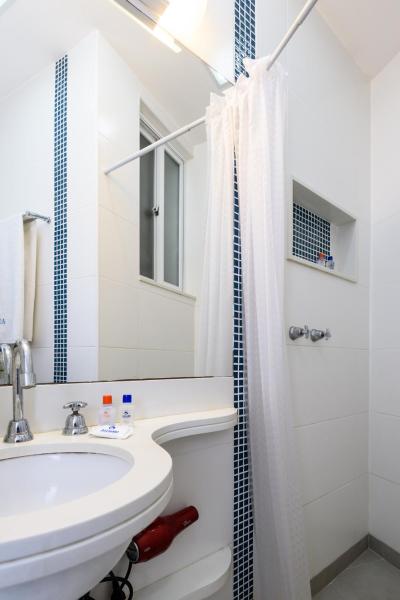 y baño blanco con lavabo y ducha. en Pineapples DF219 - Apartamento a 100m da Praia de Copacabana perfeito para casais, en Río de Janeiro