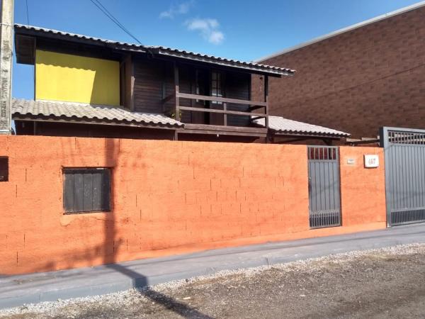 a orange brick wall with a building in the background at Casa no Campeche com Piscina in Florianópolis