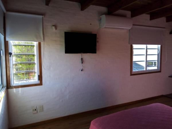 un dormitorio con un televisor de pantalla plana en la pared en DÚPLEX AL SUR en Villa Gesell