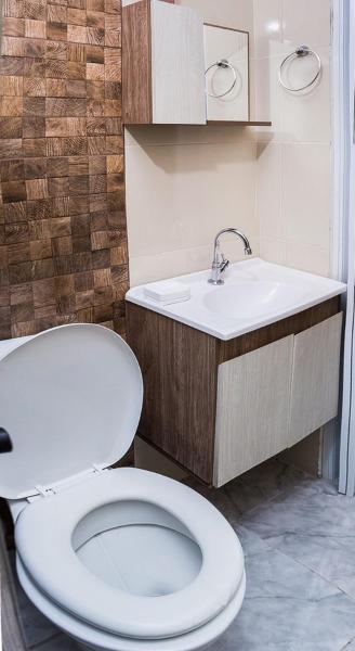 y baño con aseo blanco y lavamanos. en Ambiente familiar e confortável, en Foz do Iguaçu