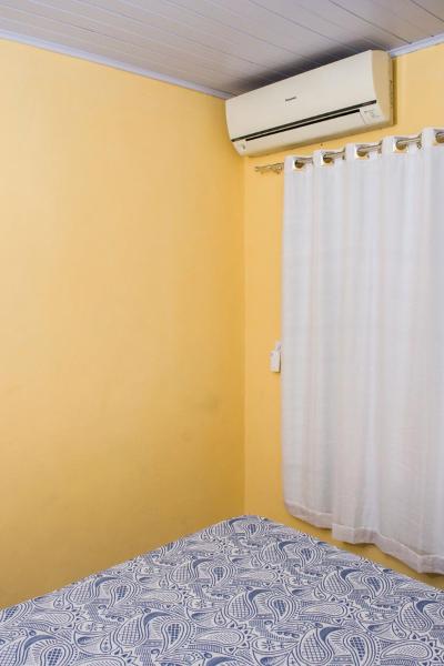 1 dormitorio con cama y cortina blanca en Ambiente familiar e confortável, en Foz do Iguaçu