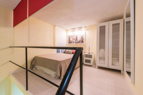 Un pequeño dormitorio con una cama y una escalera en El Monasterio de Montserrat, en Madrid