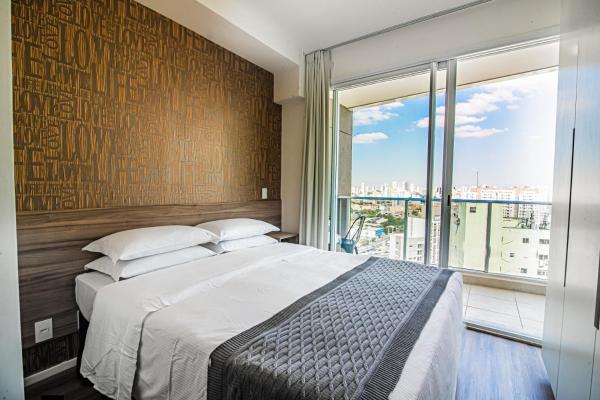 1 dormitorio con cama grande y ventana grande en 360 Suítes Sé - Apartamentos mobiliados, en São Paulo